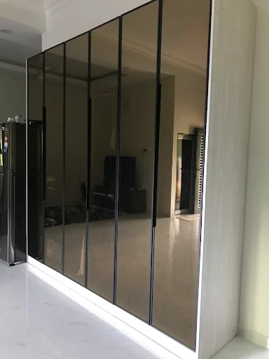 Almari pintu kaca gelap yang dipasang di rumah pelanggan