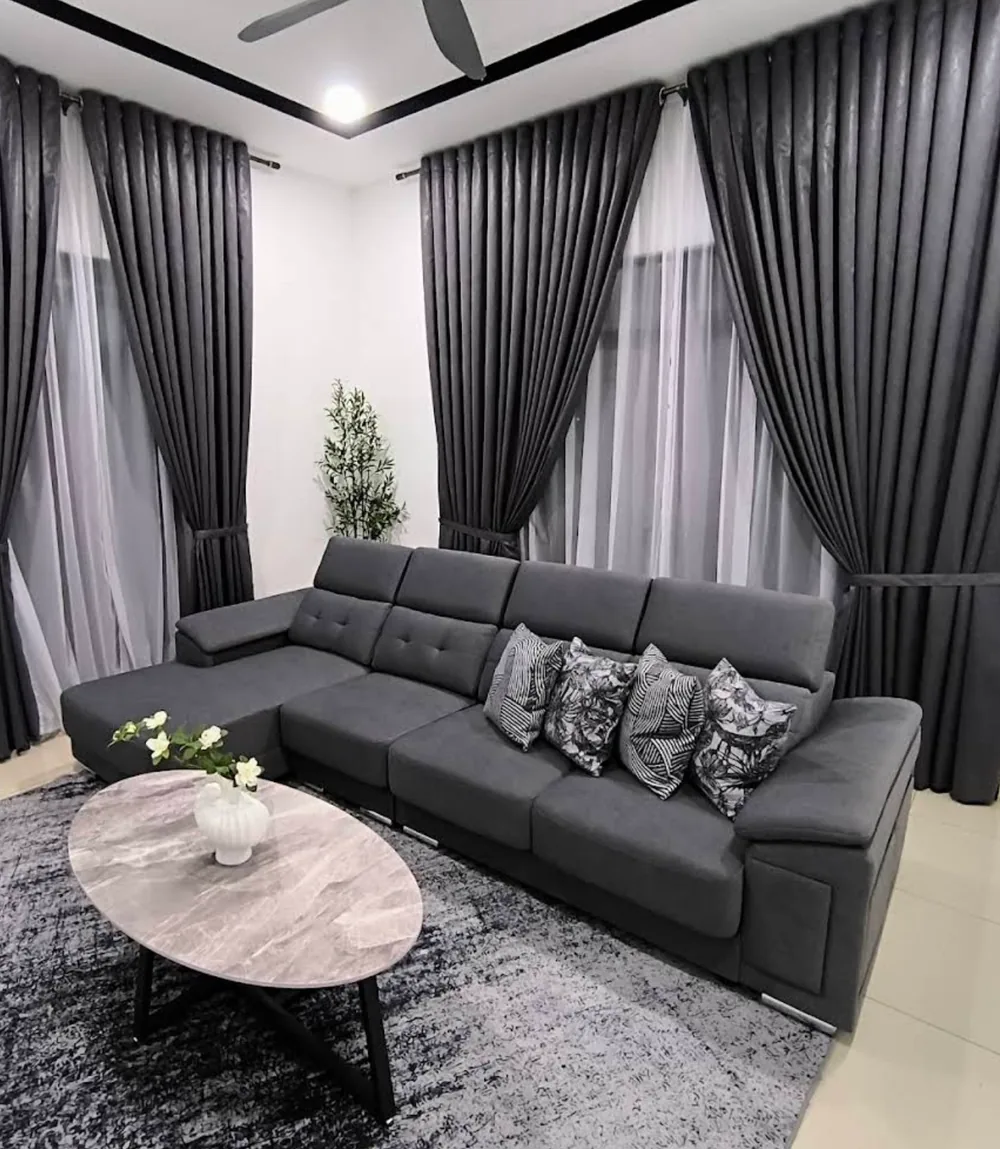 Sofa L-shape kelabu dan meja kopi marble di ruang tamu pelanggan